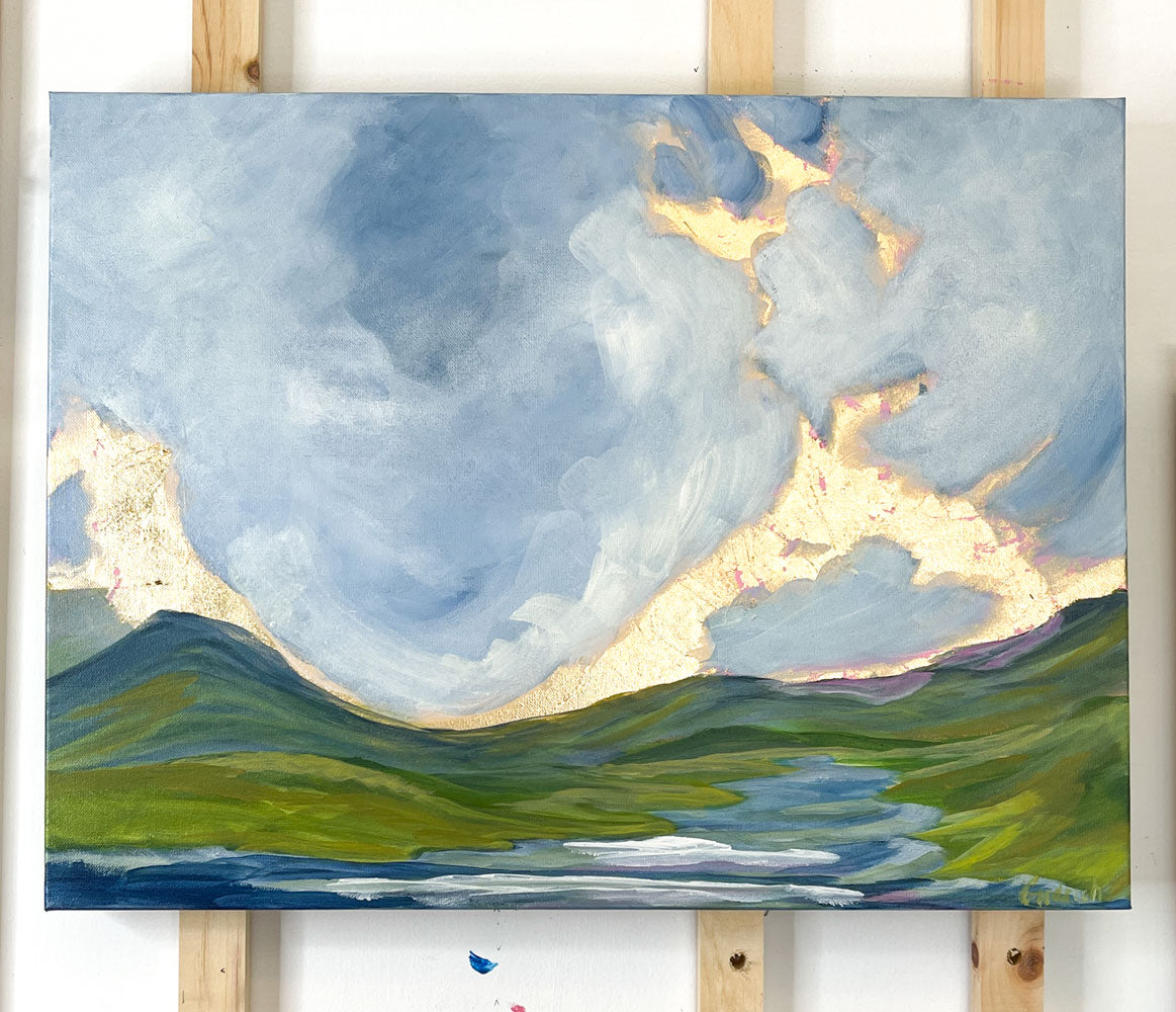 Introducing Pastel Skies VIII: a large, original landscape painting featuring pastel blue clouds, green and blue ridge mountains, and a lazy floating river.
With the addition of gold leaf, this painting offers a spectacular view of peaceful pastel skies.