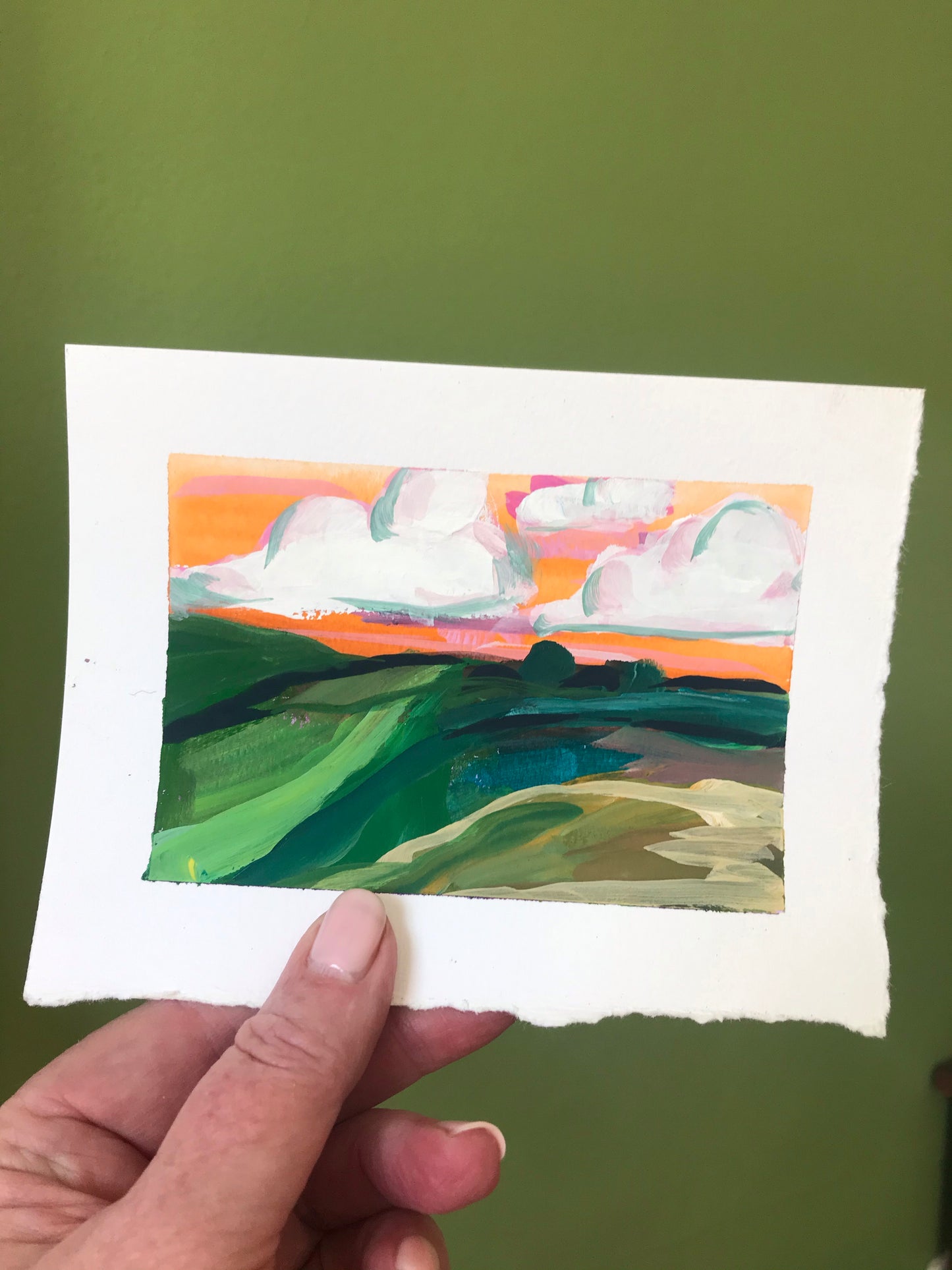 4.5 x 6”
gouache on cold press watercolor paper
Experience a vibrant and whimsical world with Crossroads.
This original impressionism style painting captures the beauty of a colorful sunset sky blending orange and pink hues, complemented by soft white clouds and lush green fields.
The Blue Ridge Mountains provide a stunning backdrop for this playful and bright mountain vista.
Add a touch of unique charm to any space with this one-of-a-kind landscape.