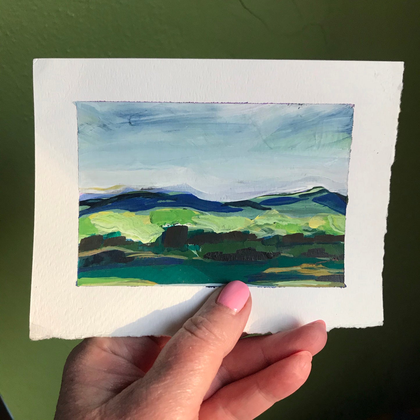 4.5 x 6”
gouache on cold press watercolor paper
Take your walls to new heights with Creatives - a stunning collection of impressionistic, modern landscapes.
Admire the bold blue skies and lush green fields, and get lost in the intricate textures of the blue ridge mountains and green tree line.
Elevate your space with this colorful and vibrant artwork!
